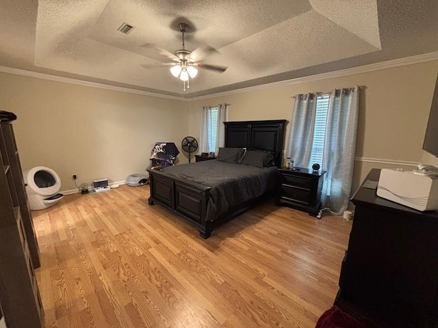 112 Vixen Ct, Dothan, AL 36305 - bedroom featuring a tray ceiling, multiple windows, a textured ceiling, light wood-type flooring, and ornamental molding