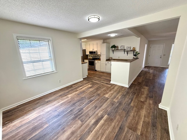 2419 Creekwood Dr, Dothan, AL 36301 - kitchen featuring stainless steel appliances, dark wood finished floors, white cabinets, dark countertops, and a textured ceiling