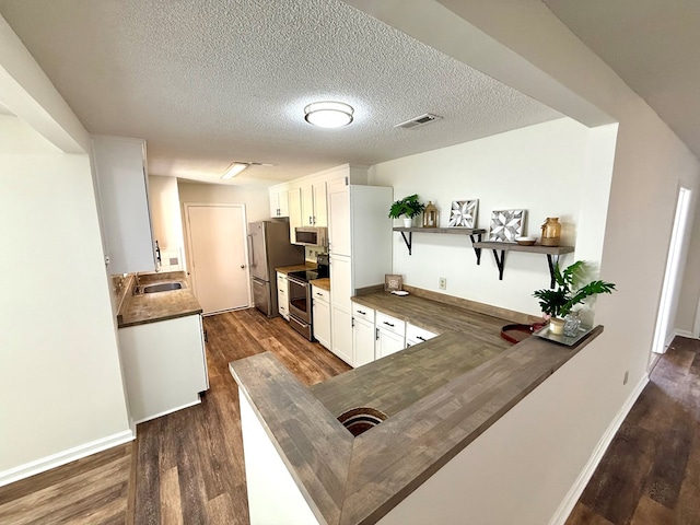 2419 Creekwood Dr, Dothan, AL 36301 - kitchen with appliances with stainless steel finishes, dark wood finished floors, open shelves, dark countertops, and a textured ceiling