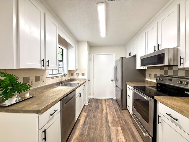2419 Creekwood Dr, Dothan, AL 36301 - kitchen with appliances with stainless steel finishes, wooden counters, dark wood-style flooring, white cabinetry, and a textured ceiling
