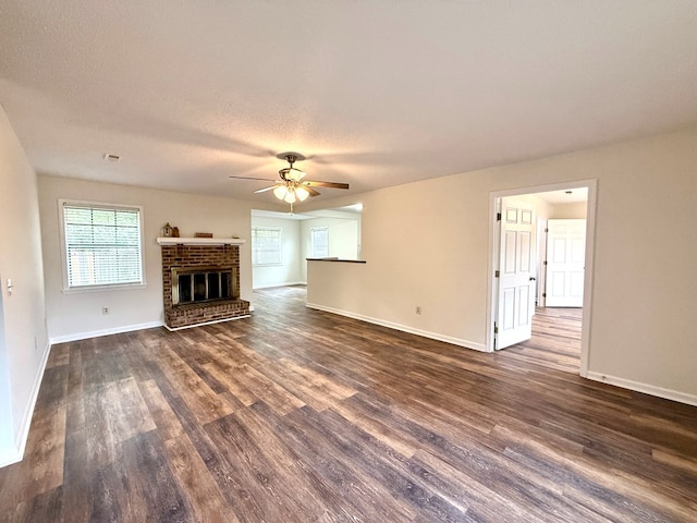 2419 Creekwood Dr, Dothan, AL 36301 - unfurnished living room featuring dark wood-type flooring, a ceiling fan, a brick fireplace, and a textured ceiling