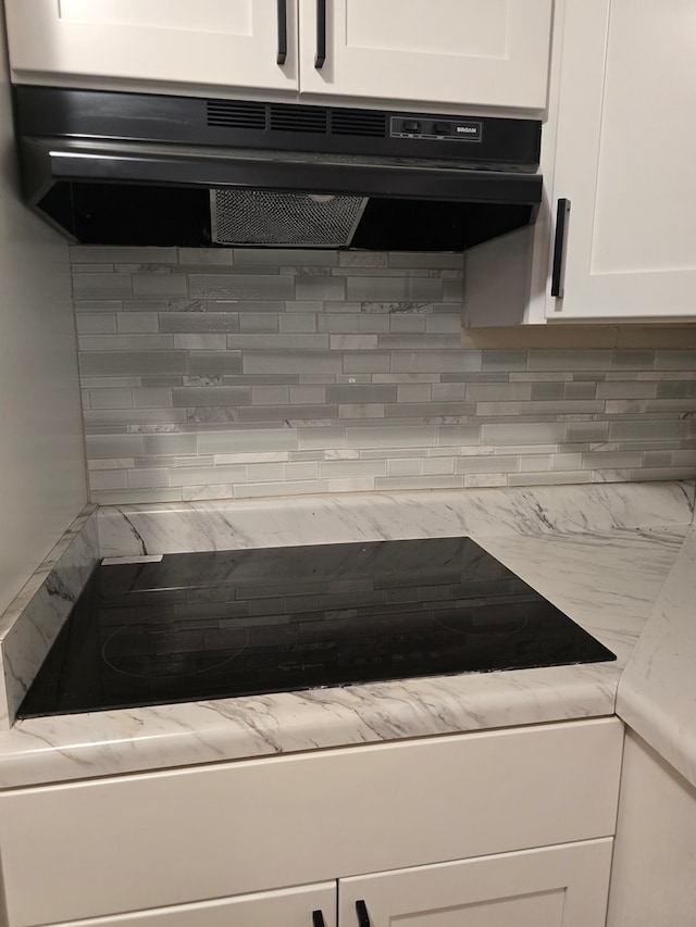 100 Pridmore St, Daleville, AL 36322 - kitchen view of under cabinet range hood, white cabinets, tasteful backsplash, and light countertops