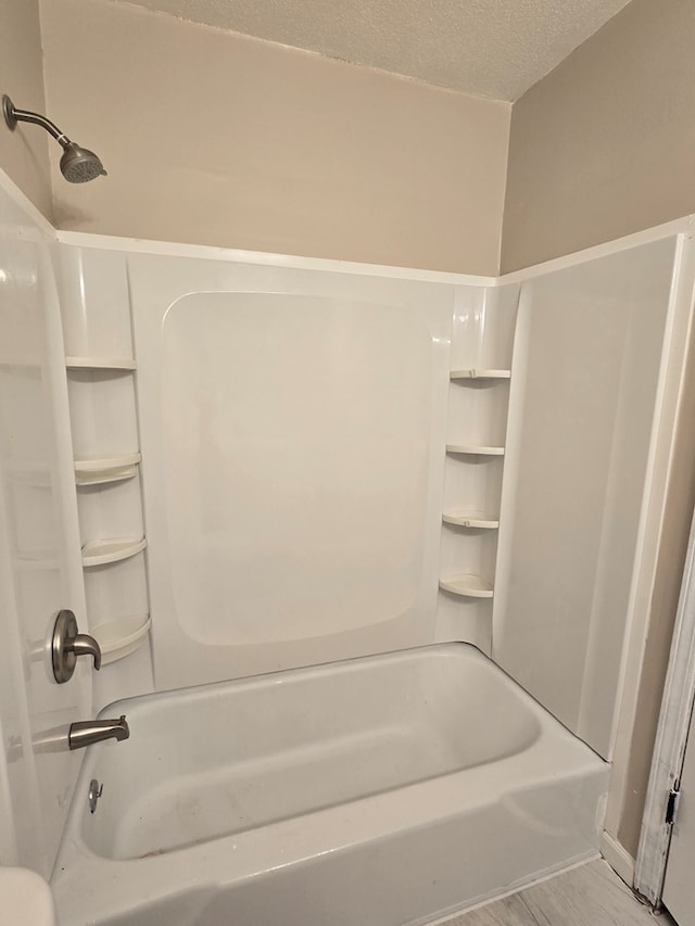 100 Pridmore St, Daleville, AL 36322 - bathroom featuring tub / shower combination, a textured ceiling, and wood finished floors