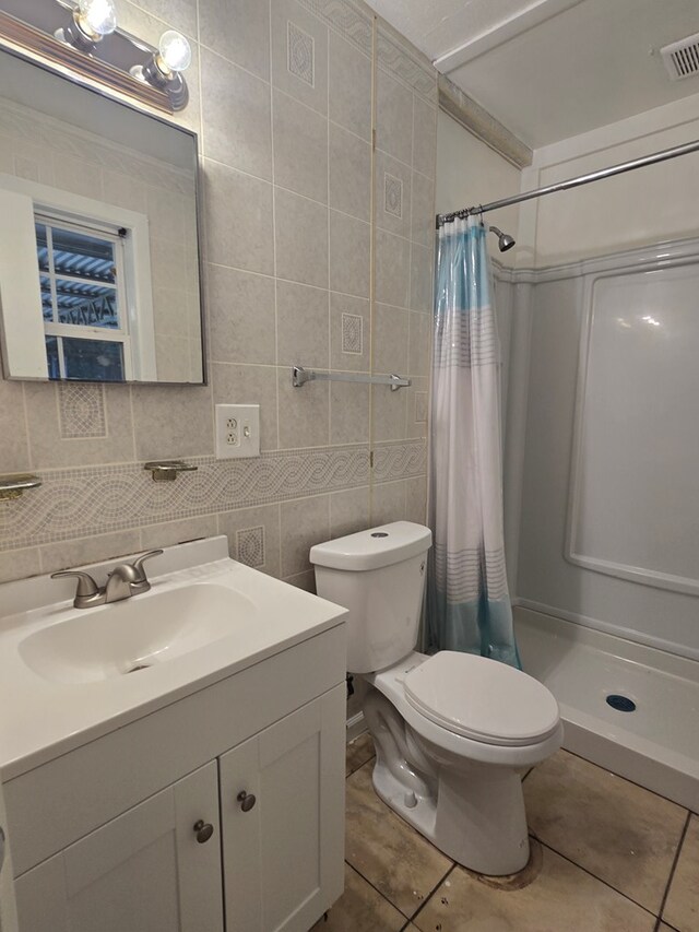100 Pridmore St, Daleville, AL 36322 - full bath featuring tile patterned floors, a shower stall, toilet, vanity, and tile walls