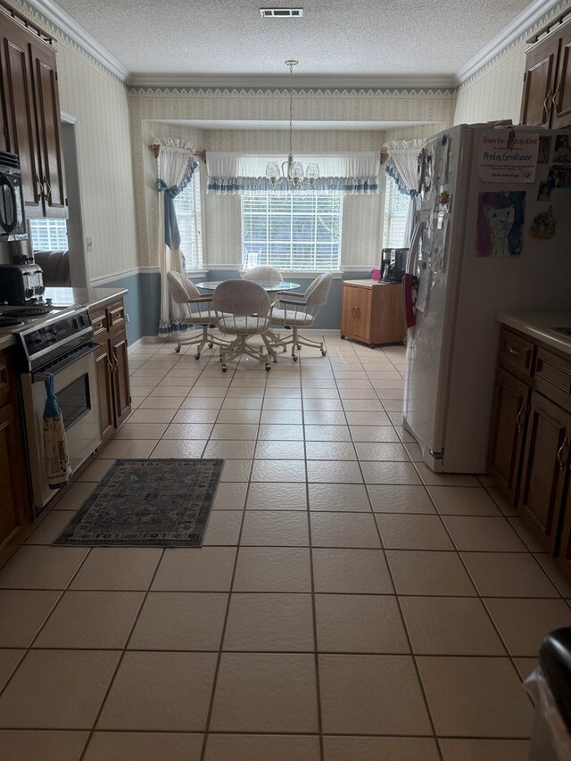 104 Wellston Ct, Dothan, AL 36305 - kitchen featuring crown molding, stainless steel electric range oven, wallpapered walls, a textured ceiling, and white fridge with ice dispenser
