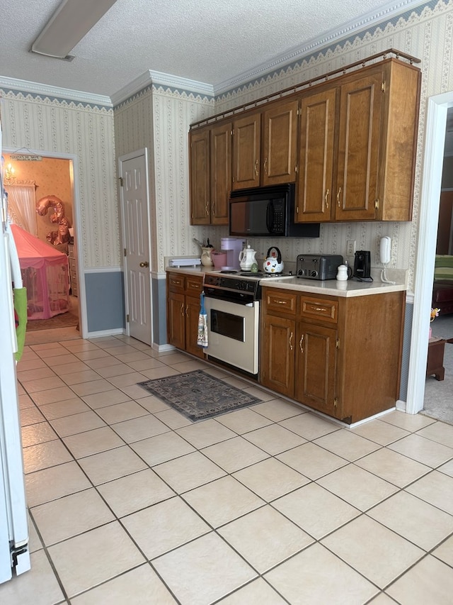 104 Wellston Ct, Dothan, AL 36305 - kitchen featuring white appliances, wallpapered walls, light countertops, a textured ceiling, and light tile patterned floors