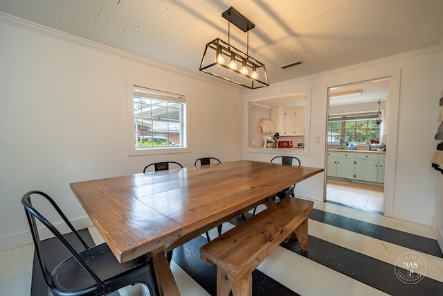 dining room with crown molding and sink