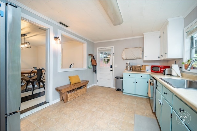 kitchen featuring white cabinets, ornamental molding, hanging light fixtures, and a healthy amount of sunlight