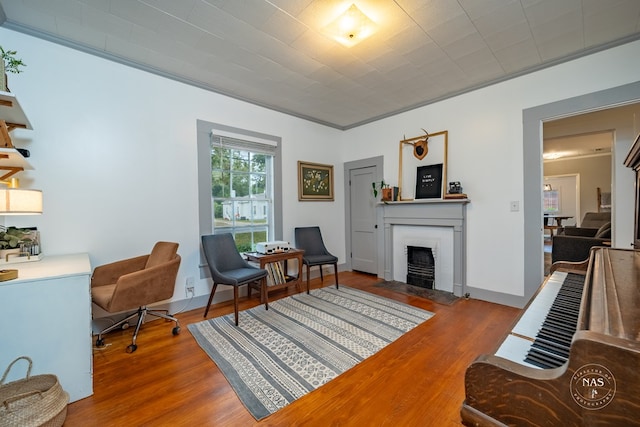 interior space with a fireplace, wood-type flooring, and ornamental molding