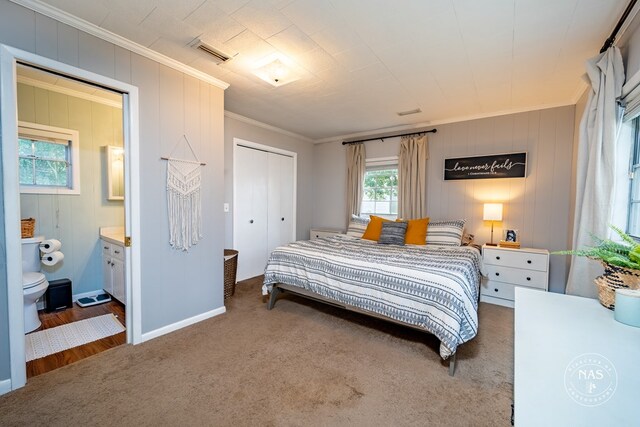 bedroom featuring carpet, ensuite bath, and crown molding