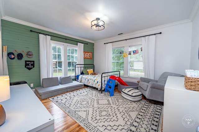 bedroom featuring crown molding and light hardwood / wood-style flooring