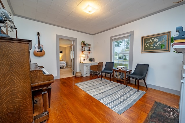 living area featuring crown molding and wood-type flooring