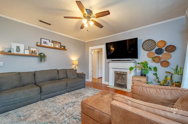 living room featuring hardwood / wood-style floors, ceiling fan, and crown molding