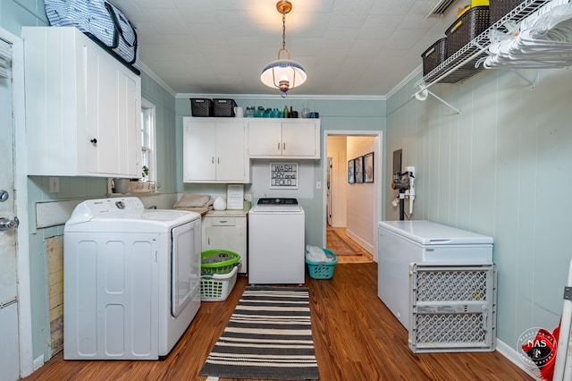 laundry area with cabinets, crown molding, washer and dryer, and dark wood-type flooring