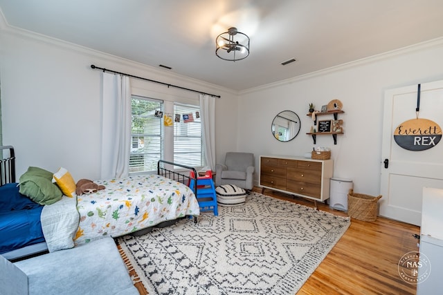 bedroom with hardwood / wood-style floors and ornamental molding