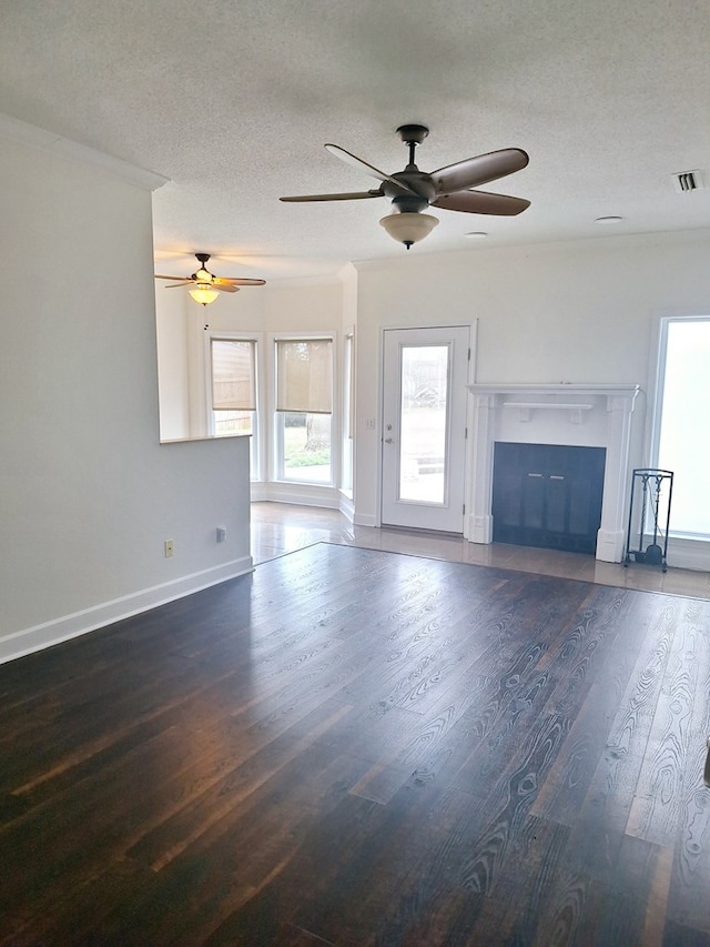 unfurnished living room featuring a textured ceiling and dark hardwood / wood-style flooring