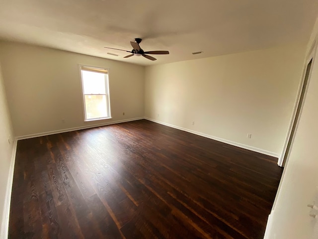 empty room with dark wood-type flooring and ceiling fan