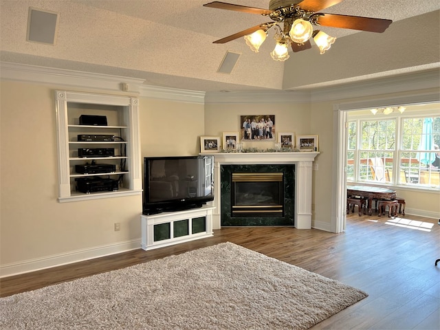 3374 Lake Oak Ridge Dr, Enterprise, AL 36330 - living room featuring wood finished floors, a high end fireplace, ornamental molding, a ceiling fan, and a textured ceiling