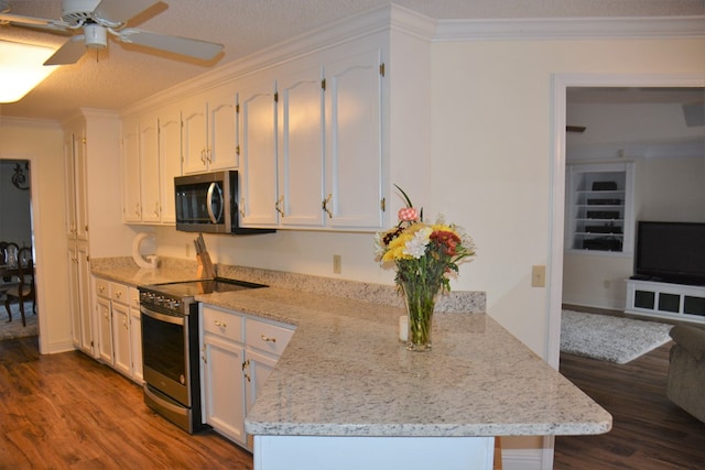 3374 Lake Oak Ridge Dr, Enterprise, AL 36330 - kitchen with appliances with stainless steel finishes, dark wood-style flooring, white cabinets, ornamental molding, and a ceiling fan