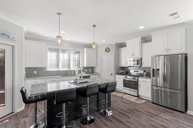 kitchen with a kitchen island, sink, white cabinetry, a breakfast bar area, and stainless steel appliances