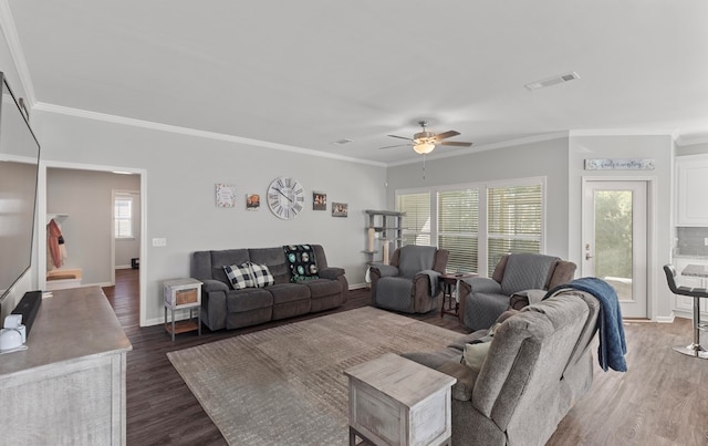 living room featuring plenty of natural light, dark hardwood / wood-style flooring, and ornamental molding