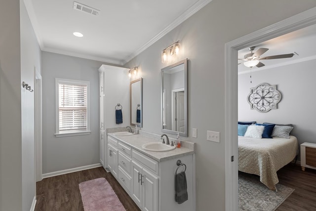 bathroom featuring ceiling fan, ornamental molding, hardwood / wood-style floors, and vanity