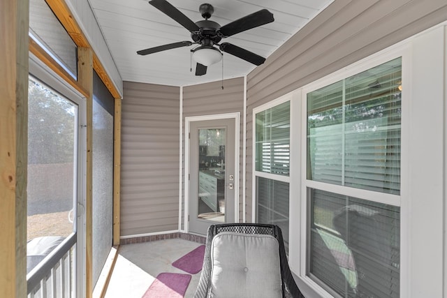 unfurnished sunroom with ceiling fan