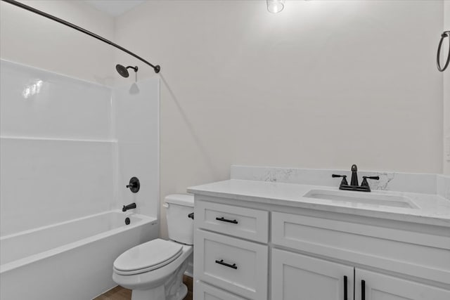 bathroom with wood finished floors, toilet, vanity, and bathtub / shower combination
