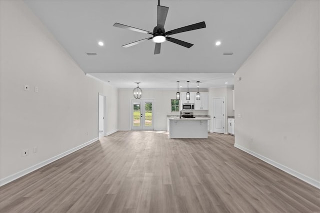 unfurnished living room with light wood-type flooring, french doors, baseboards, and ceiling fan