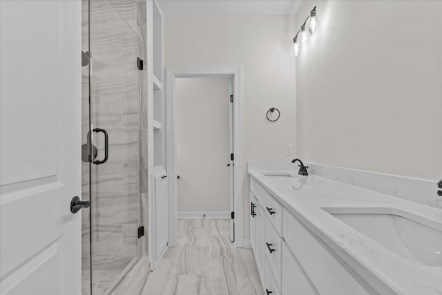 full bath featuring marble finish floor, a sink, double vanity, and a stall shower