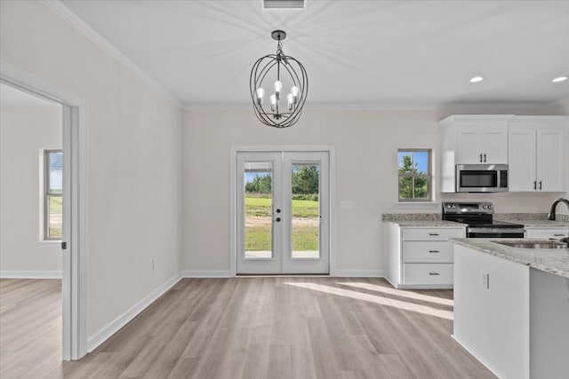 kitchen featuring light stone countertops, light wood finished floors, stainless steel appliances, and a sink