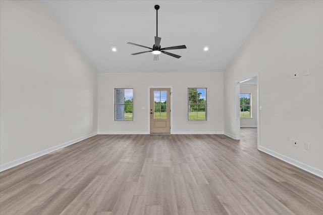 unfurnished living room featuring high vaulted ceiling, ceiling fan, a wealth of natural light, and wood finished floors