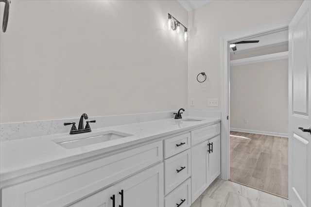 bathroom with marble finish floor, a sink, and double vanity