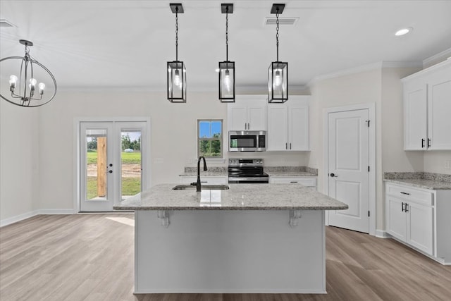 kitchen with a sink, light wood-style floors, appliances with stainless steel finishes, ornamental molding, and visible vents