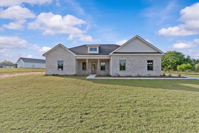 view of front of home featuring brick siding and a front yard