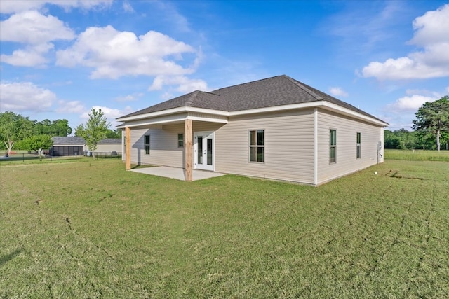 back of property with a lawn, fence, a patio area, and french doors