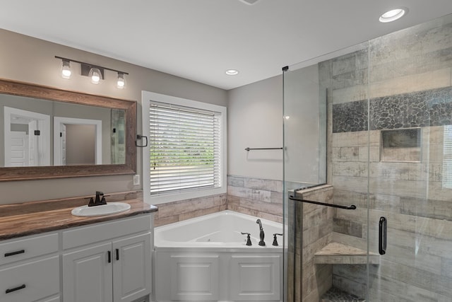 bathroom featuring shower with separate bathtub and vanity