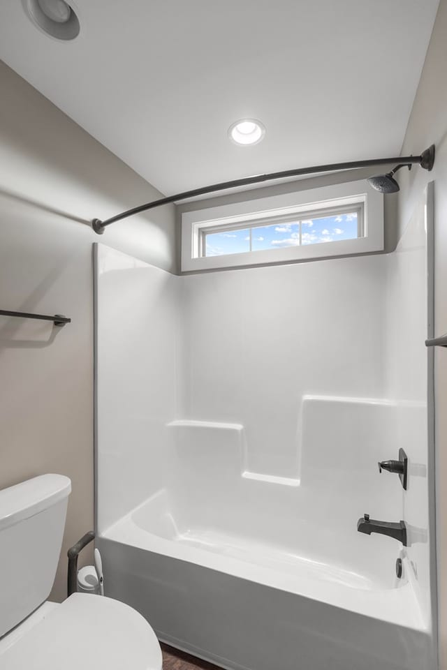 bathroom featuring shower / tub combination and toilet