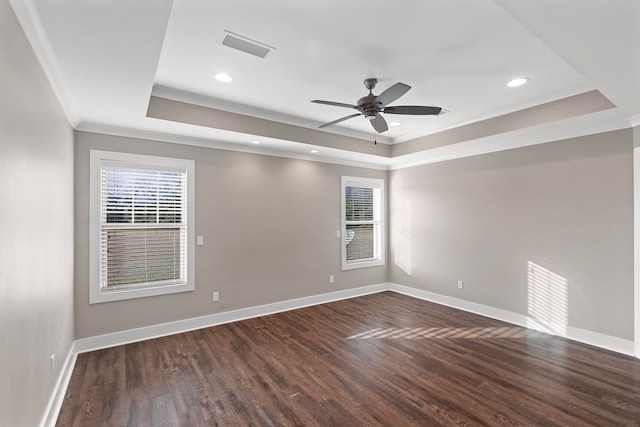 spare room featuring a raised ceiling, crown molding, dark wood-type flooring, and ceiling fan