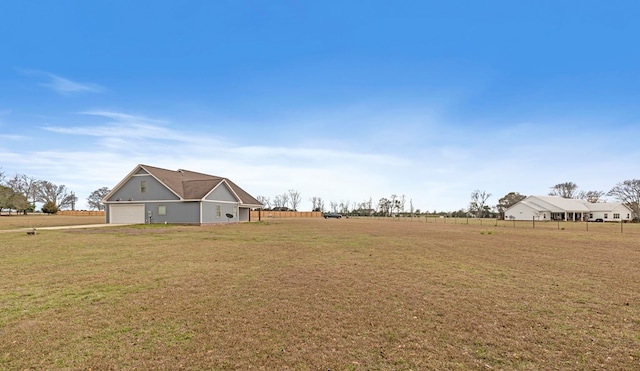 view of yard with a garage and a rural view