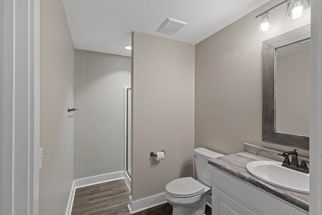 bathroom with hardwood / wood-style flooring, vanity, and toilet