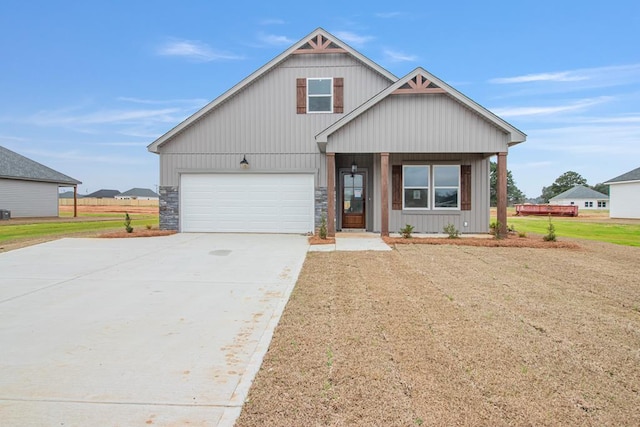 view of front of home with a garage, a porch, and a front yard