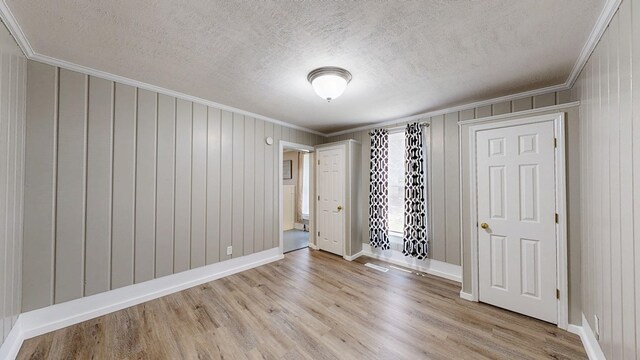 431 E Eufaula St, Ozark, AL 36360 - empty room with crown molding, light wood-type flooring, a textured ceiling, and baseboards