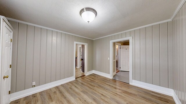 431 E Eufaula St, Ozark, AL 36360 - spare room with crown molding, light wood-style flooring, baseboards, and a textured ceiling