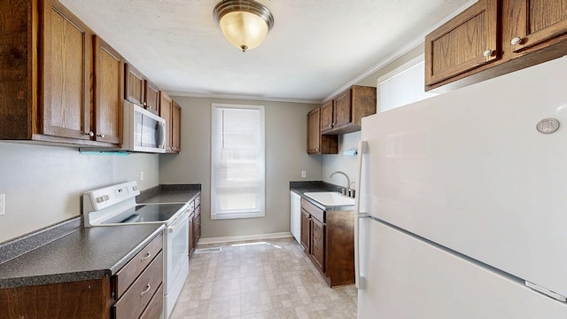 431 E Eufaula St, Ozark, AL 36360 - kitchen with white appliances, a sink, dark countertops, baseboards, and crown molding