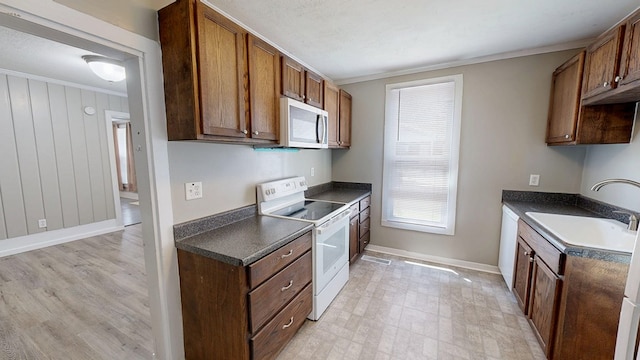 431 E Eufaula St, Ozark, AL 36360 - kitchen with white electric range, a sink, dark countertops, baseboards, and ornamental molding