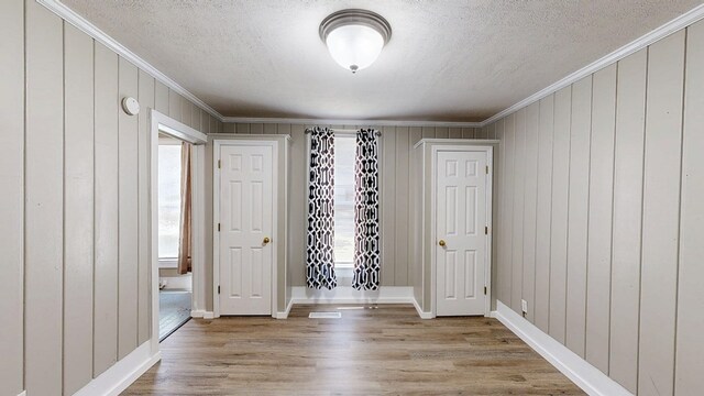 431 E Eufaula St, Ozark, AL 36360 - empty room with ornamental molding, a textured ceiling, wood finished floors, baseboards, and wooden walls