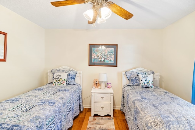 bedroom featuring light wood finished floors, ceiling fan, and a textured ceiling