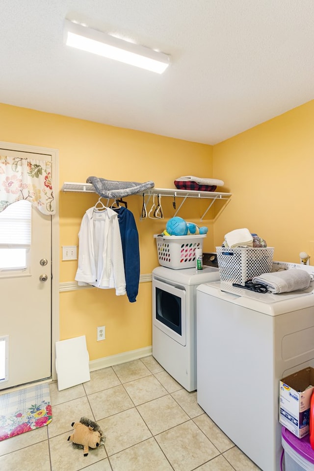 washroom with laundry area, washing machine and dryer, and light tile patterned floors