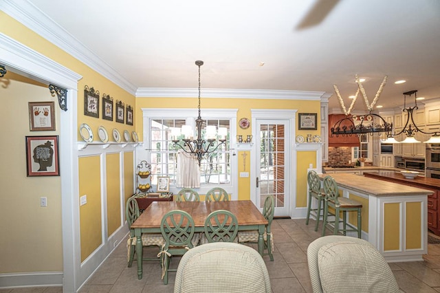 tiled dining space with an inviting chandelier and ornamental molding